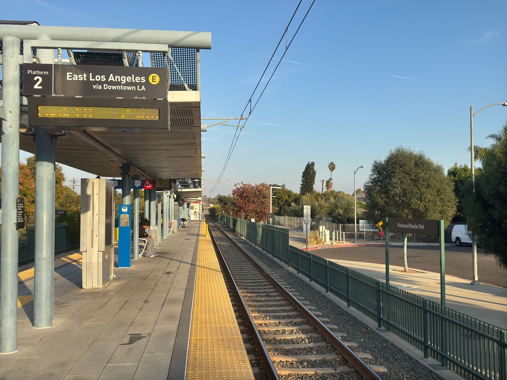 East Los Angeles train station platform with empty tracks during sunset.