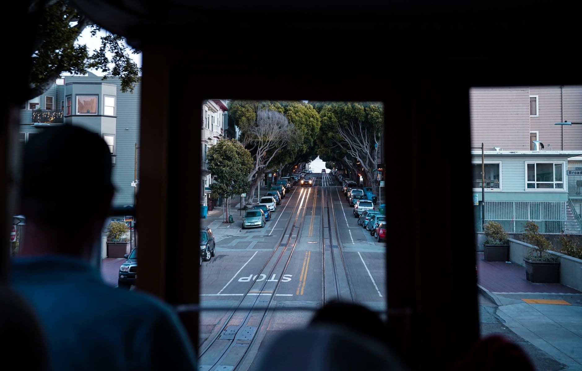 A scenic view of San Francisco streets from inside a moving cable car, highlighting urban transportation.
